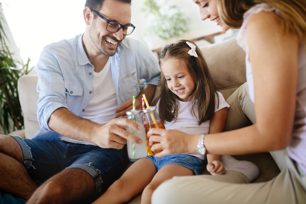 Happy family drinking juice together in their house