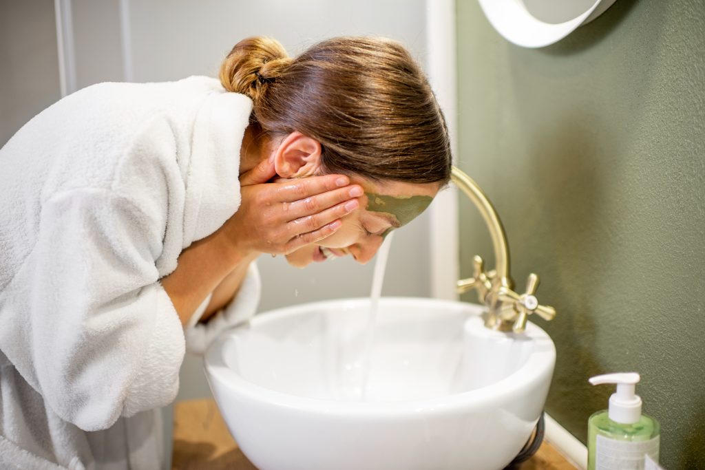 Woman washing face in the bathroom