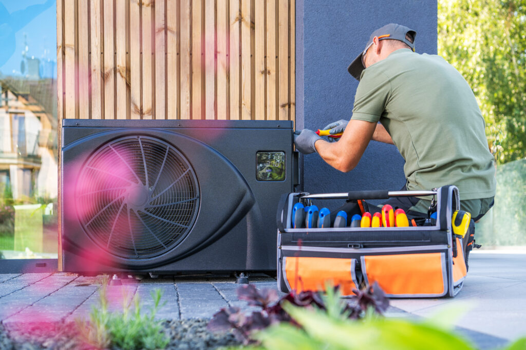 Technician Installing Air Conditioning Unit at Residential Property During Daytime